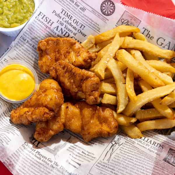 Go Brit! fish and chips with mushy peas and tartar sauce, served on newspaper.